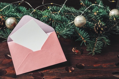 Blank greeting card in envelope and Christmas decor on wooden table, closeup. Space for text Photo of Blank greeting card in envelope and Christmas decor on wooden table, closeup. Space for text