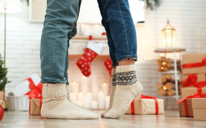 Couple in warm socks in room decorated for Christmas, closeup Image of Couple in warm socks in room decorated for Christmas, closeup