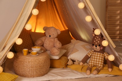 Play tent with toys and pillows indoors, closeup. Modern children's room interior Photo of Play tent with toys and pillows indoors, closeup. Modern children's room interior