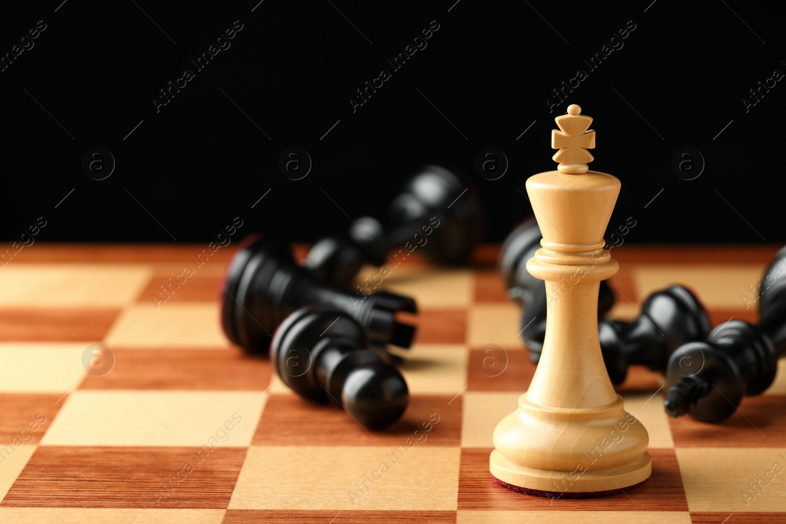 Photo of Chessboard with game pieces on black background, closeup. Space for text