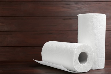 Rolls of paper towels on wooden table Photo of Rolls of paper towels on wooden table