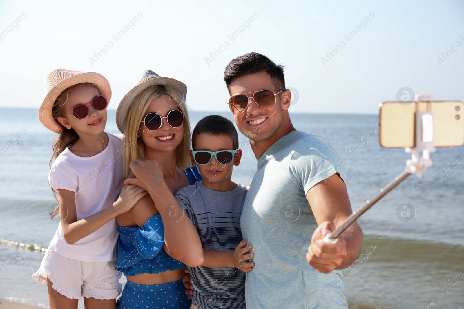 Happy family taking selfie at beach on sunny day Photo of Happy family taking selfie at beach on sunny day