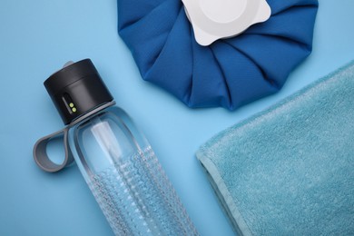 Bottle of water, cold compress and towel on light blue background, flat lay. Heat stroke treatment Photo of Bottle of water, cold compress and towel on light blue background, flat lay. Heat stroke treatment