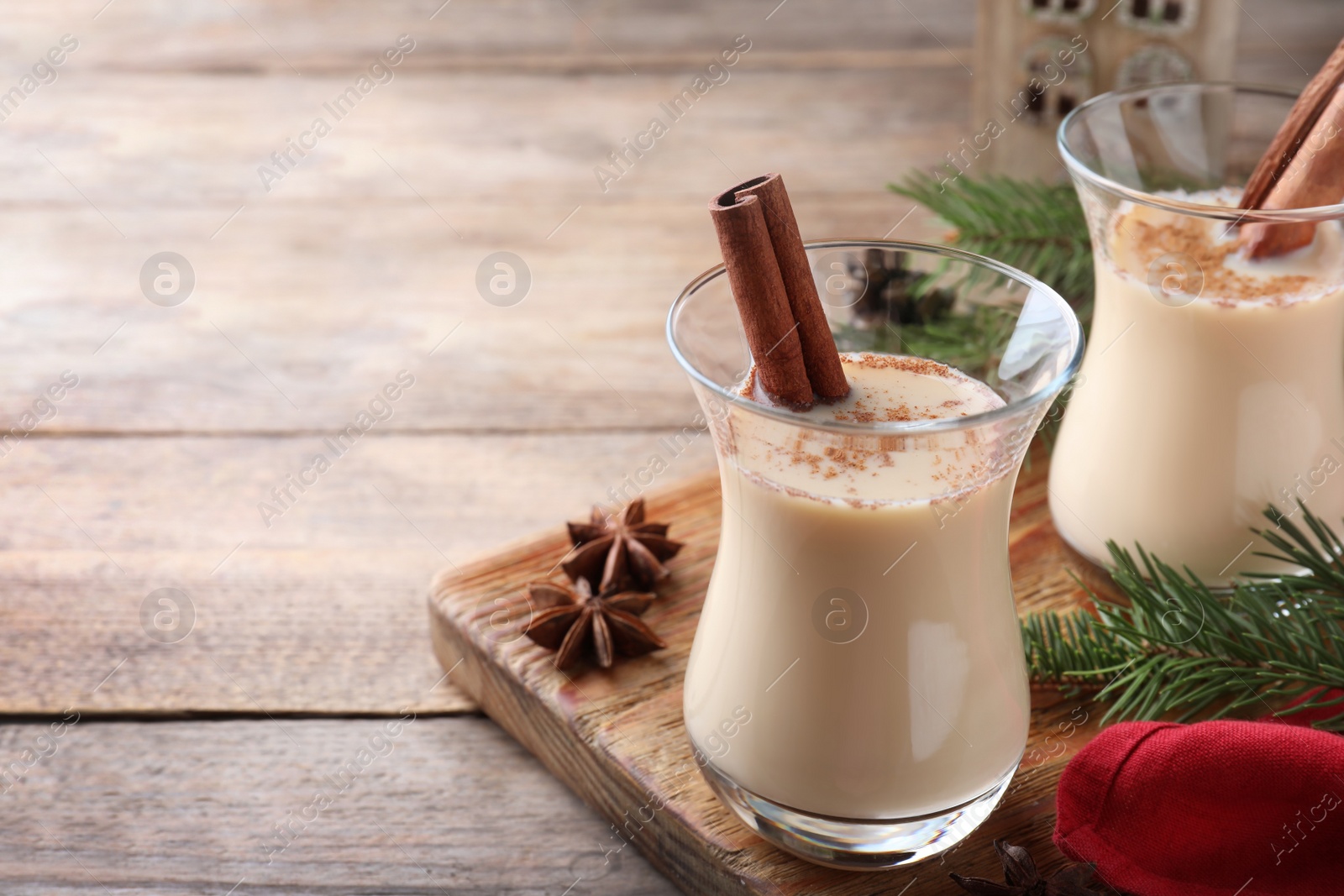 Photo of Delicious Christmas liqueur on wooden table, closeup. Space for text