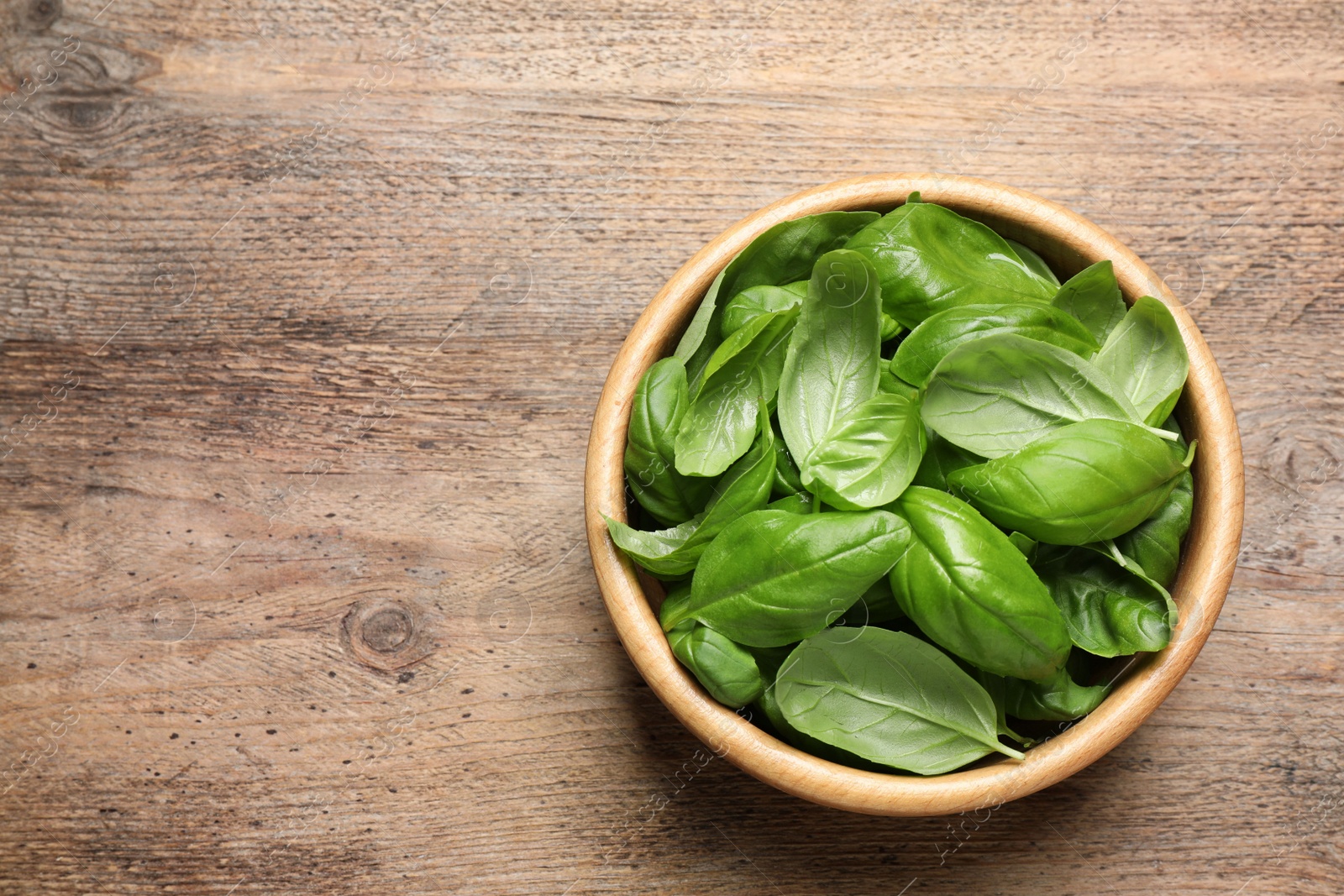 Fresh basil on wooden table, top view. Space for text Photo of Fresh basil on wooden table, top view. Space for text