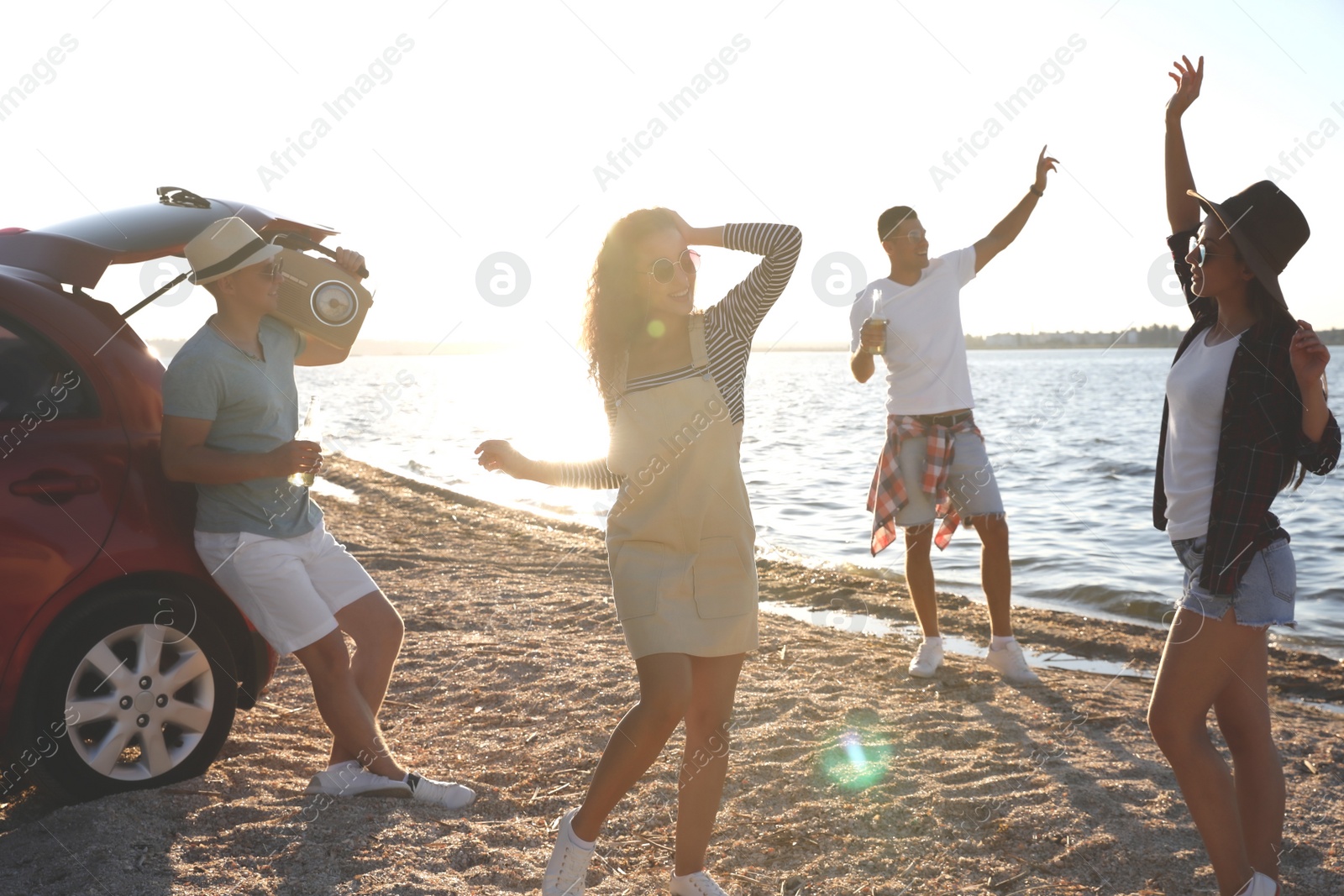 Happy friends having fun near car on beach. Summer trip Photo of Happy friends having fun near car on beach. Summer trip