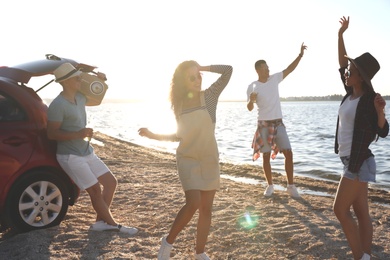 Happy friends having fun near car on beach. Summer trip Photo of Happy friends having fun near car on beach. Summer trip