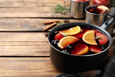 Delicious mulled wine and ingredients on wooden table. Space for text Photo of Delicious mulled wine and ingredients on wooden table. Space for text