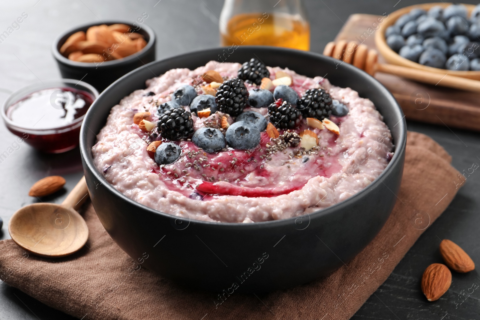 Tasty oatmeal porridge with toppings in bowl served on table, closeup Photo of Tasty oatmeal porridge with toppings in bowl served on table, closeup