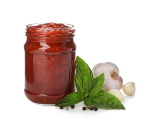 Delicious adjika sauce in glass jar and ingredients isolated on white Photo of Delicious adjika sauce in glass jar and ingredients isolated on white