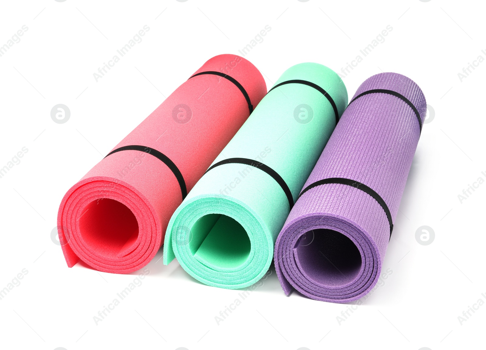 Colorful rolled camping or exercise mats on white background Photo of Colorful rolled camping or exercise mats on white background
