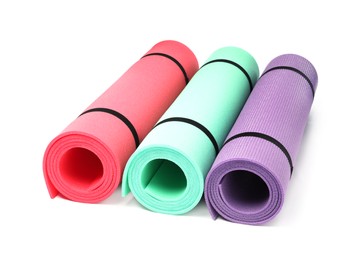 Colorful rolled camping or exercise mats on white background Photo of Colorful rolled camping or exercise mats on white background