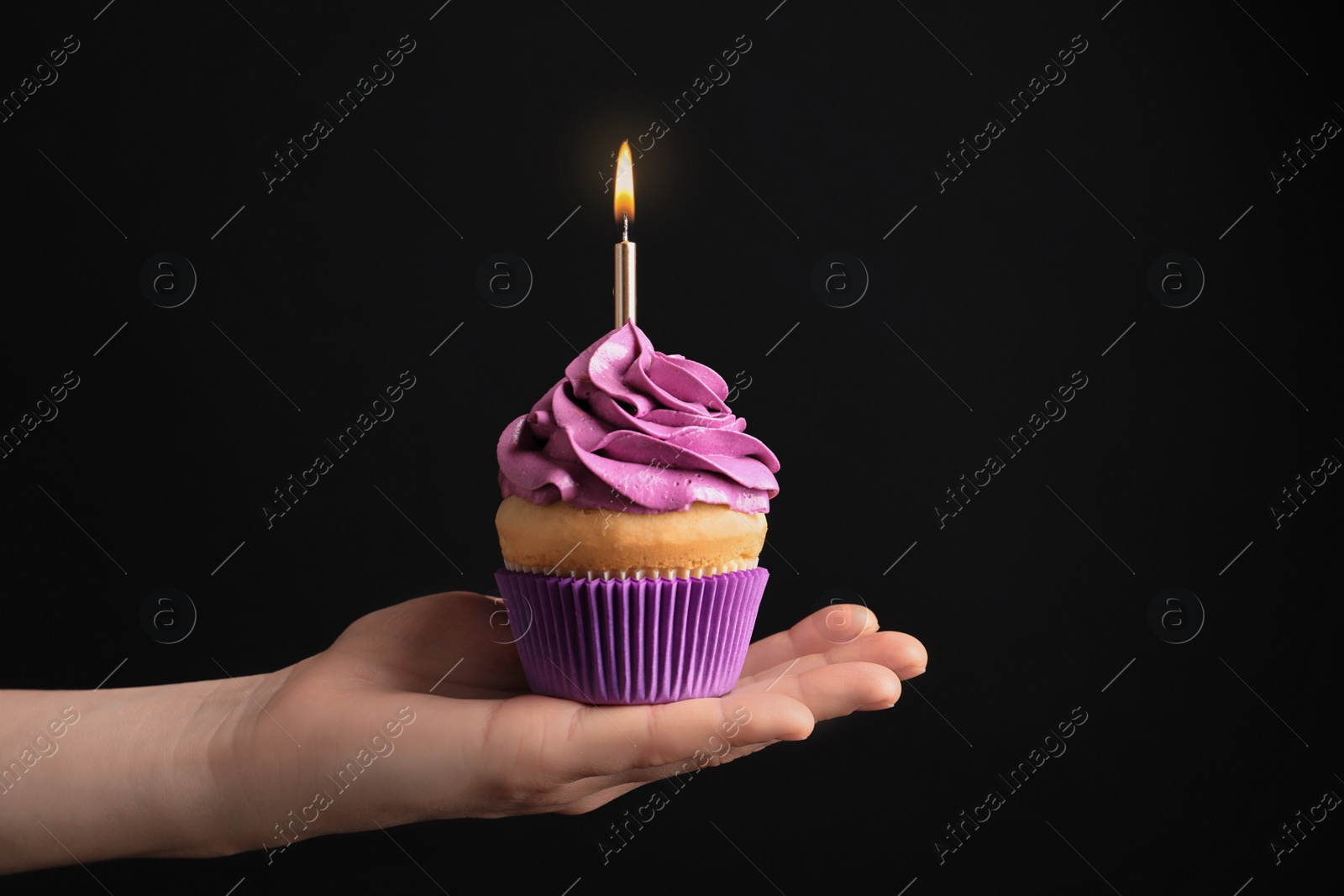 Woman holding birthday cupcake on black background Photo of Woman holding birthday cupcake on black background
