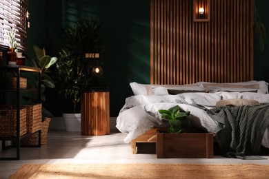 Stylish interior with large comfortable bed and potted plants Photo of Stylish interior with large comfortable bed and potted plants