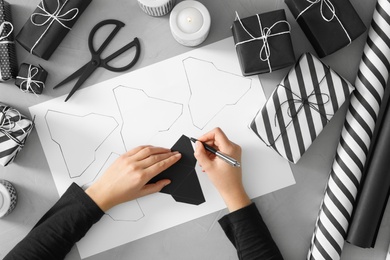 Woman making advent calendar at grey table, top view Photo of Woman making advent calendar at grey table, top view
