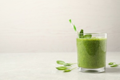Green juice and fresh spinach leaves on light grey table. Space for text Photo of Green juice and fresh spinach leaves on light grey table. Space for text