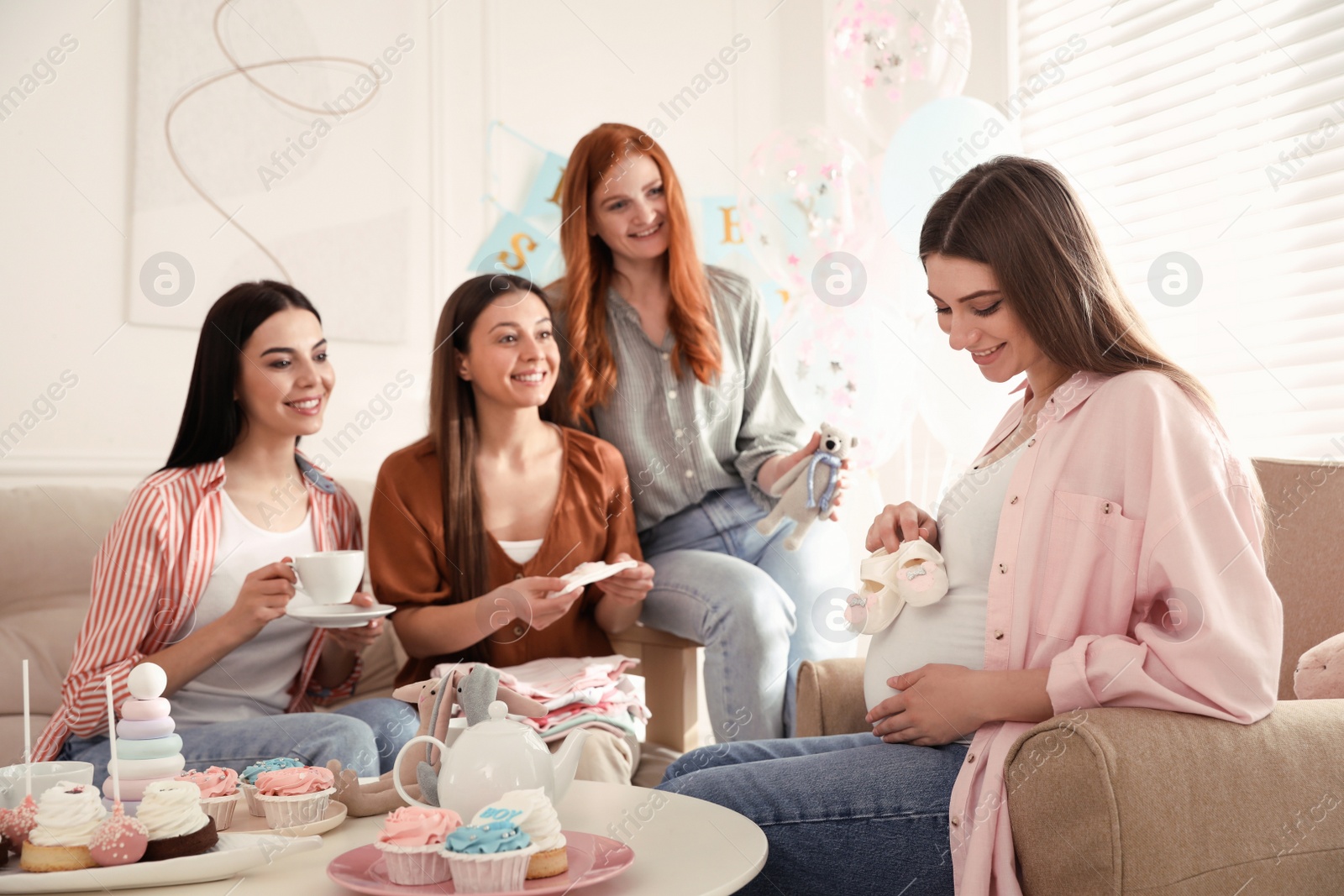 Happy pregnant woman spending time with friends at baby shower party Photo of Happy pregnant woman spending time with friends at baby shower party