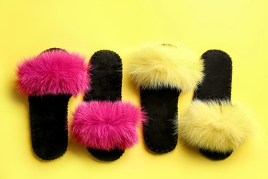 Different soft slippers on yellow background, flat lay Photo of Different soft slippers on yellow background, flat lay