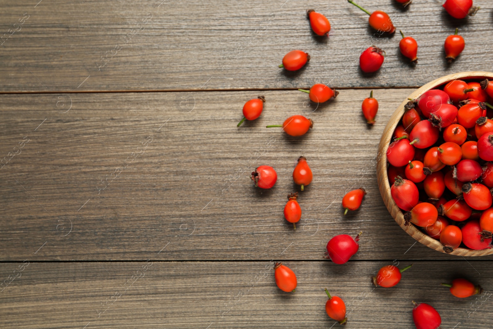 Ripe rose hip berries on wooden table, flat lay. Space for text Photo of Ripe rose hip berries on wooden table, flat lay. Space for text