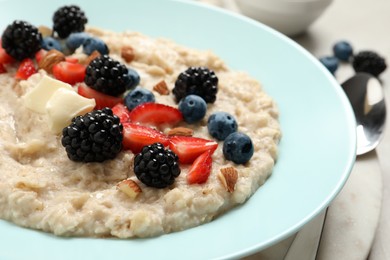 Tasty oatmeal porridge with berries and almond nuts in plate, closeup Photo of Tasty oatmeal porridge with berries and almond nuts in plate, closeup