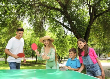 Happy family playing ping pong in park Photo of Happy family playing ping pong in park