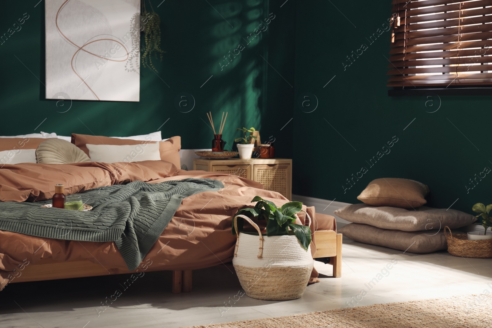 Stylish interior with large comfortable bed and potted plants Photo of Stylish interior with large comfortable bed and potted plants