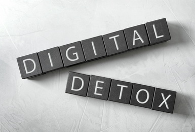 Black cubes with words DIGITAL DETOX on white background, flat lay Photo of Black cubes with words DIGITAL DETOX on white background, flat lay