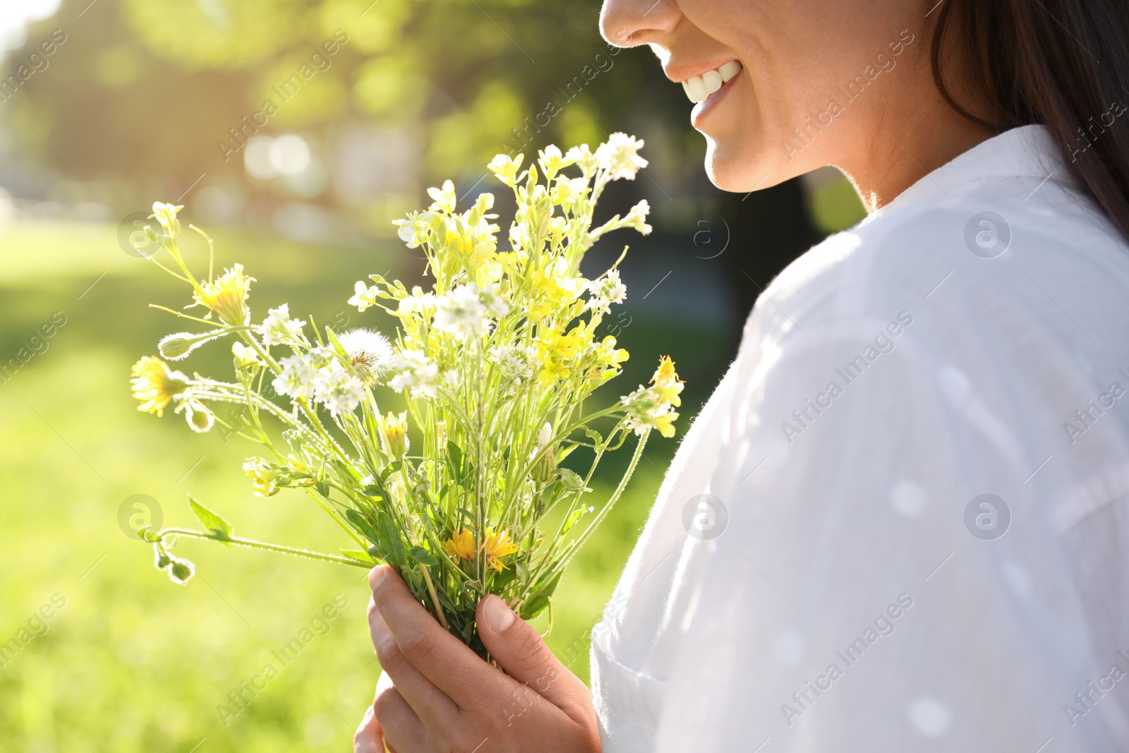 Young woman with beautiful bouquet outdoors on sunny day, closeup Photo of Young woman with beautiful bouquet outdoors on sunny day, closeup