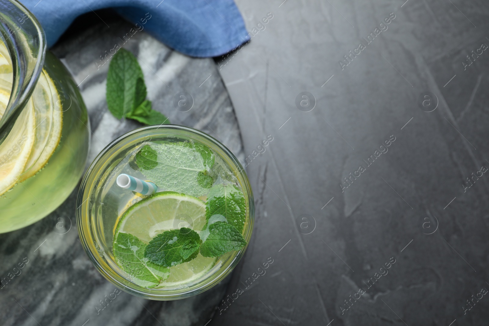 Delicious lemonade made with soda water and fresh mint on grey table, flat lay. Space for text Photo of Delicious lemonade made with soda water and fresh mint on grey table, flat lay. Space for text