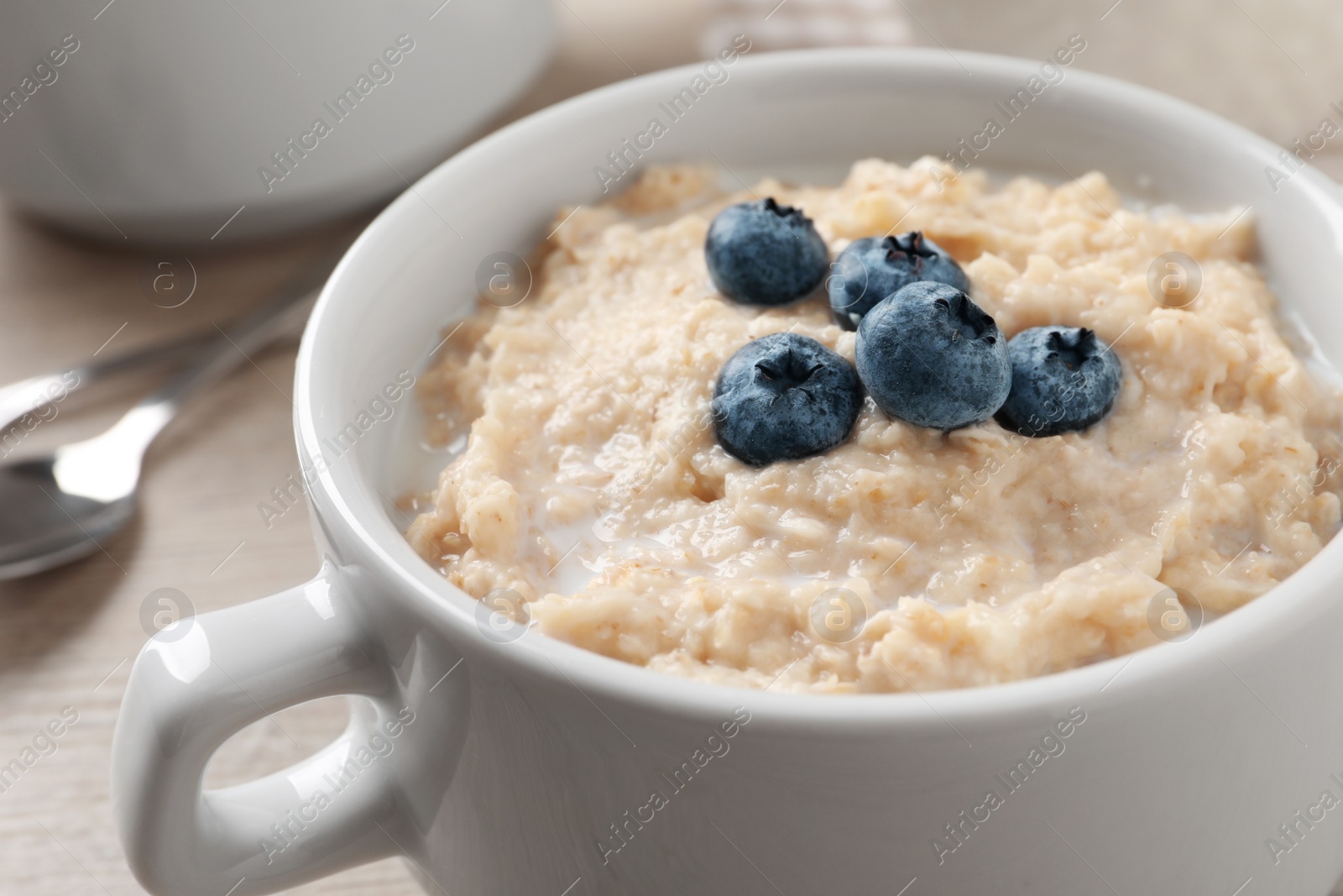 Tasty oatmeal porridge with blueberries in bowl on table, closeup Photo of Tasty oatmeal porridge with blueberries in bowl on table, closeup