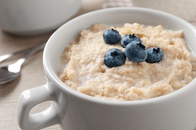 Tasty oatmeal porridge with blueberries in bowl on table, closeup Photo of Tasty oatmeal porridge with blueberries in bowl on table, closeup