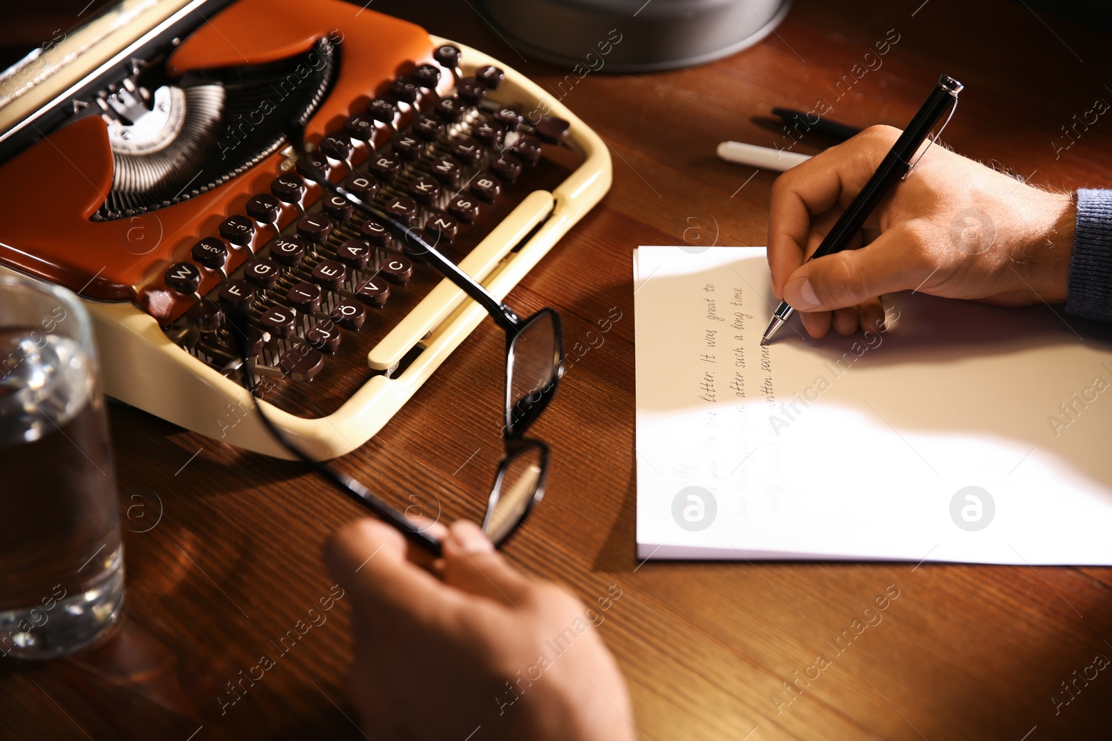Man writing letter at wooden table indoors, closeup Photo of Man writing letter at wooden table indoors, closeup