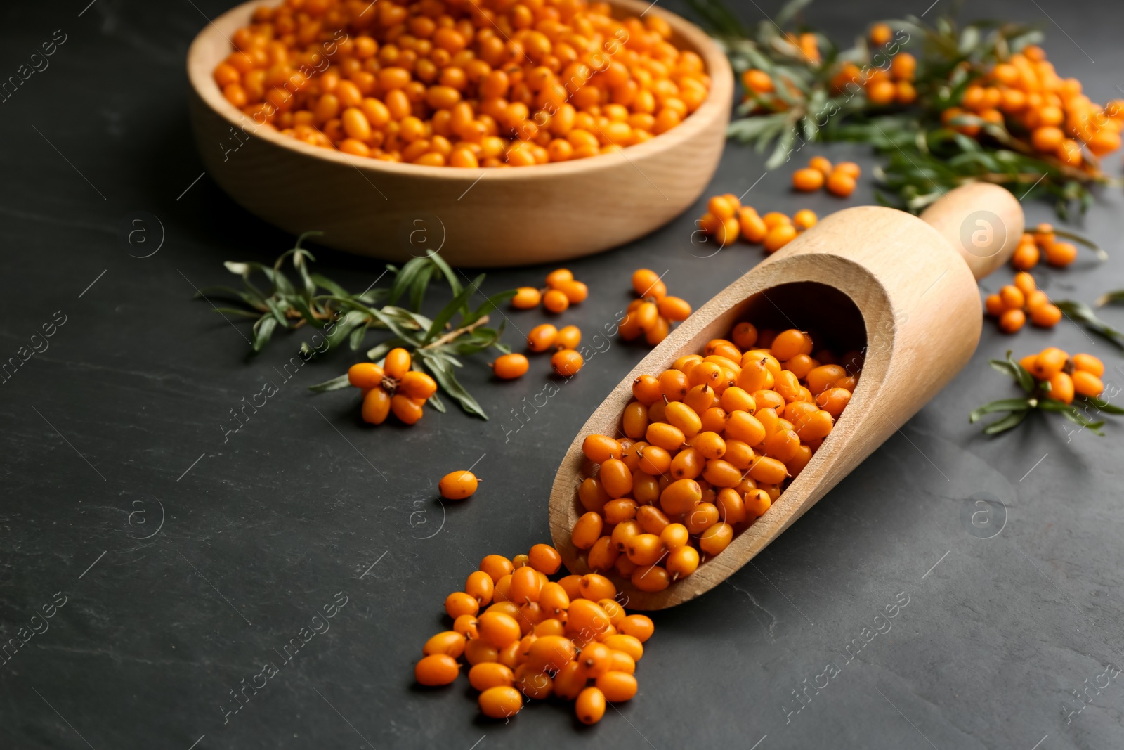 Fresh ripe sea buckthorn on black table Photo of Fresh ripe sea buckthorn on black table