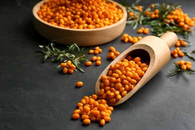 Fresh ripe sea buckthorn on black table Photo of Fresh ripe sea buckthorn on black table
