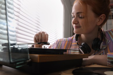 Young woman using turntable at home, closeup Photo of Young woman using turntable at home, closeup