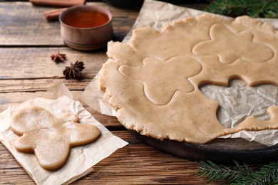 Making homemade Christmas cookies. Dough for gingerbread man on wooden table, closeup Photo of Making homemade Christmas cookies. Dough for gingerbread man on wooden table, closeup