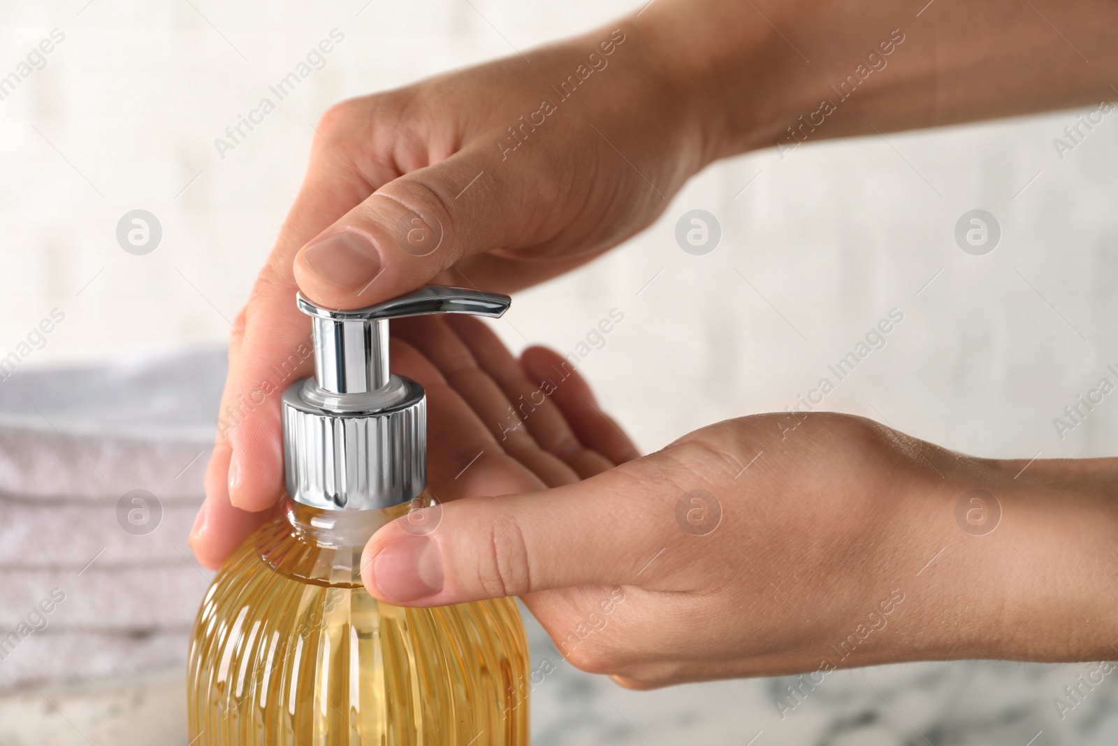 Woman using liquid soap dispenser, closeup view Photo of Woman using liquid soap dispenser, closeup view