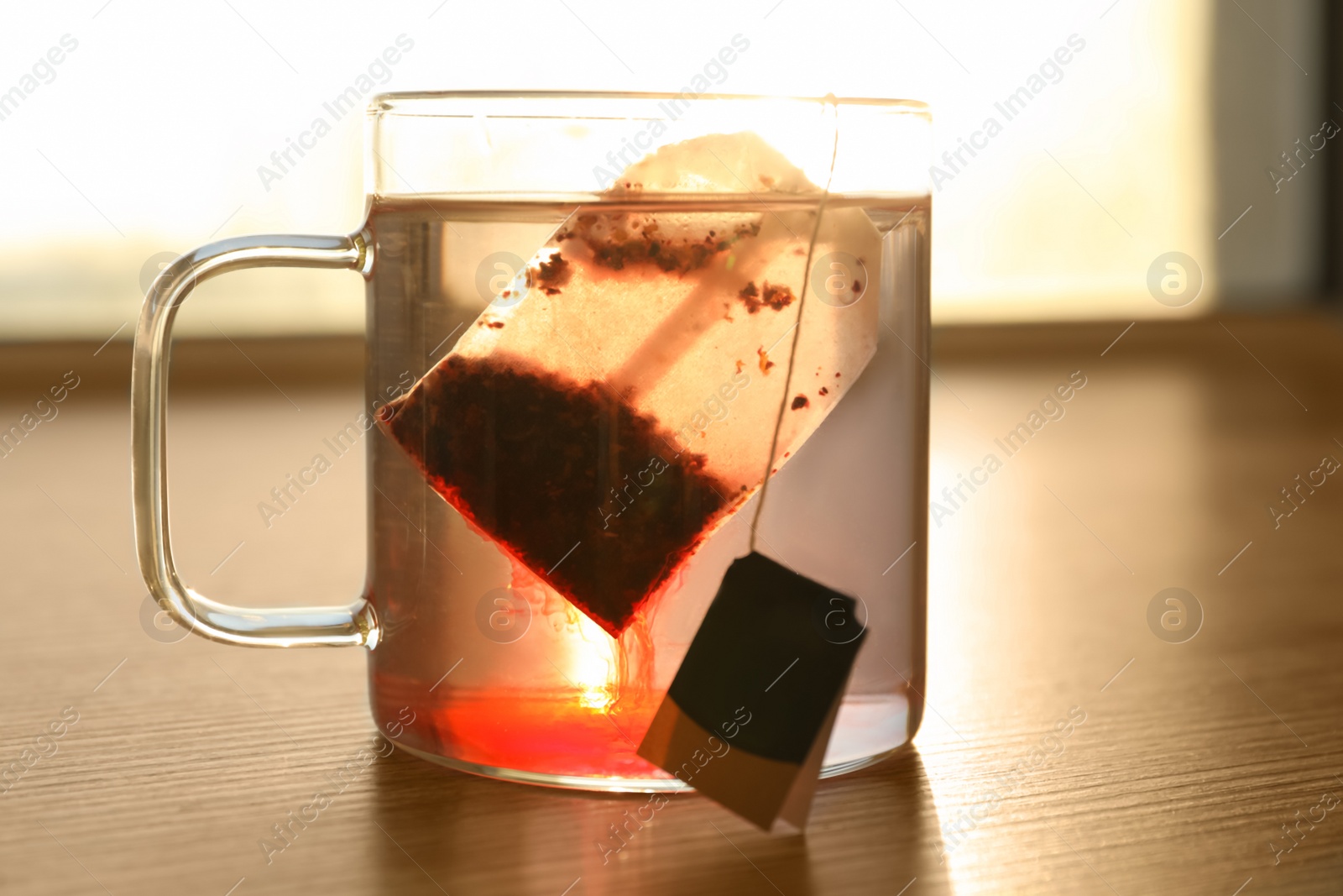 Tea bag in cup of hot water on wooden table, closeup Photo of Tea bag in cup of hot water on wooden table, closeup