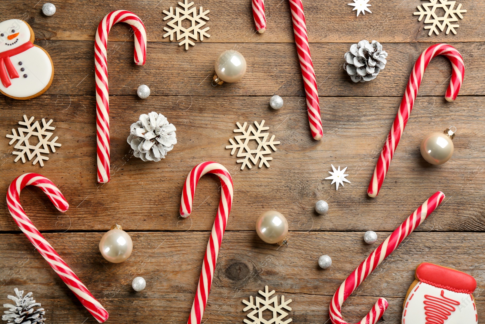 Flat lay composition with candy canes and Christmas decor on wooden background Photo of Flat lay composition with candy canes and Christmas decor on wooden background
