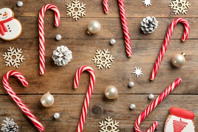 Flat lay composition with candy canes and Christmas decor on wooden background Photo of Flat lay composition with candy canes and Christmas decor on wooden background