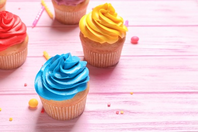 Delicious birthday cupcakes on wooden background Photo of Delicious birthday cupcakes on wooden background