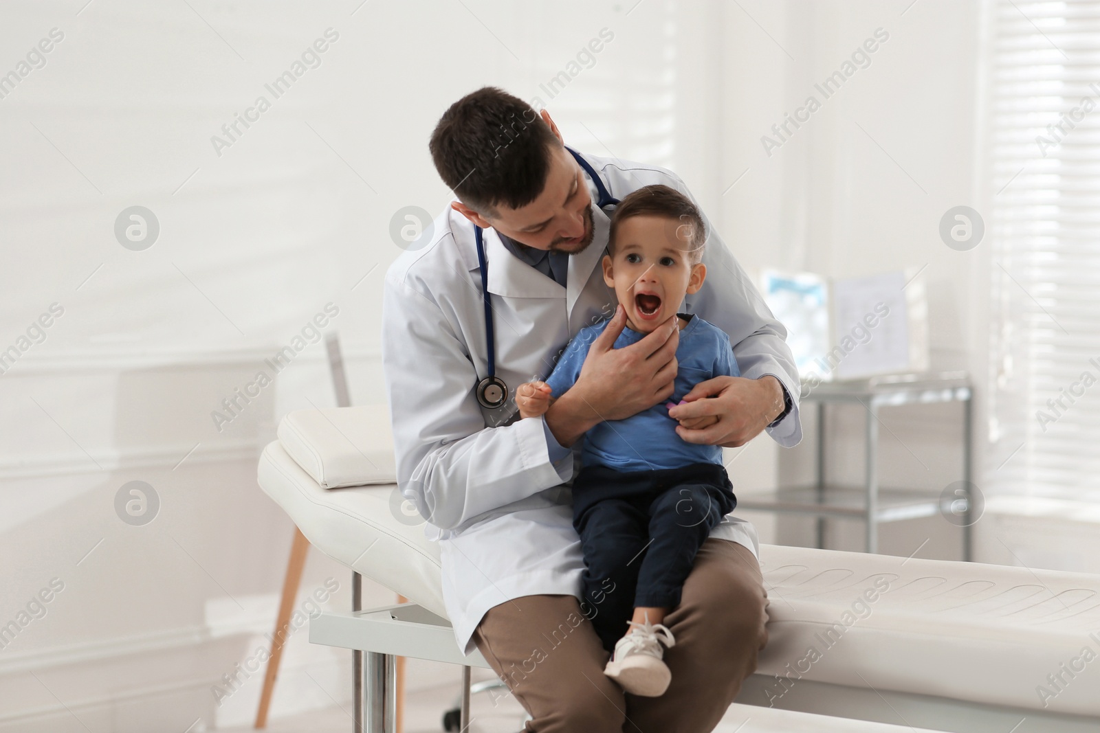 Pediatrician examining cute little boy at hospital Photo of Pediatrician examining cute little boy at hospital