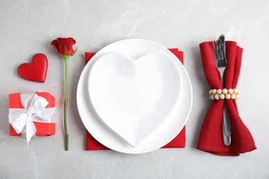 Beautiful table setting for romantic dinner on light grey background, flat lay. Valentine's day celebration Photo of Beautiful table setting for romantic dinner on light grey background, flat lay. Valentine's day celebration