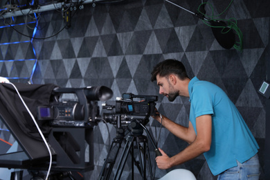 Professional video camera operator working in studio Photo of Professional video camera operator working in studio