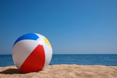 Colorful inflatable ball on sandy beach. Space for text Photo of Colorful inflatable ball on sandy beach. Space for text
