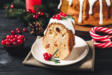 Composition with piece of traditional homemade Christmas cake on black wooden table, closeup Photo of Composition with piece of traditional homemade Christmas cake on black wooden table, closeup