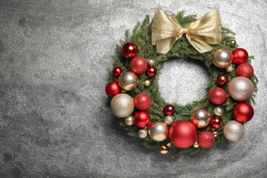 Beautiful Christmas wreath with festive decor on grey background. Space for text Photo of Beautiful Christmas wreath with festive decor on grey background. Space for text