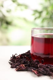 Fresh Hibiscus tea on white table against blurred background, closeup. Space for text Photo of Fresh Hibiscus tea on white table against blurred background, closeup. Space for text