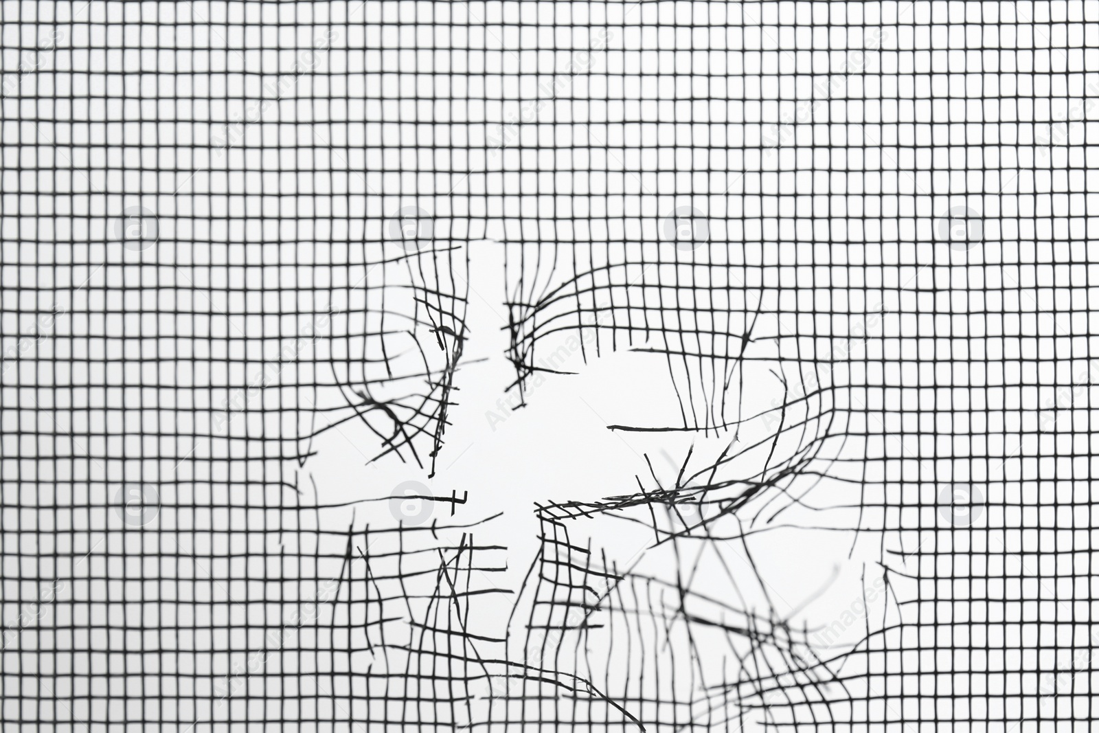 Photo of Torn window screen against white background, closeup