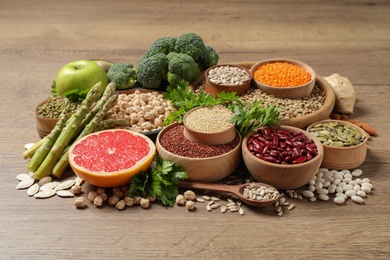 Fresh vegetables, fruits and seeds on wooden table Photo of Fresh vegetables, fruits and seeds on wooden table